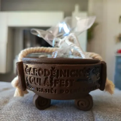 Hnědá keramická miska s nápisem Čarodějnický gulášfest, na nožičkách a s lanem